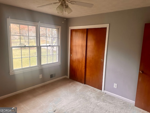 unfurnished bedroom featuring a closet, carpet flooring, and ceiling fan