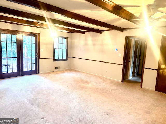 carpeted spare room with french doors and beamed ceiling