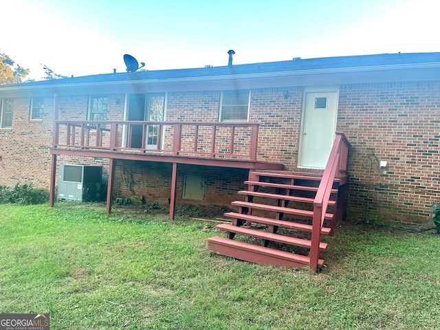 rear view of house with a wooden deck and a yard