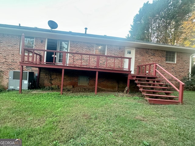 rear view of house featuring a yard and a wooden deck