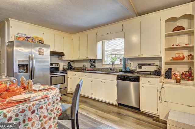 kitchen featuring stainless steel appliances, hardwood / wood-style flooring, sink, a textured ceiling, and white cabinetry