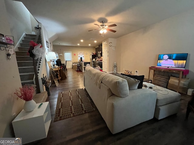 living room featuring ceiling fan and dark wood-type flooring