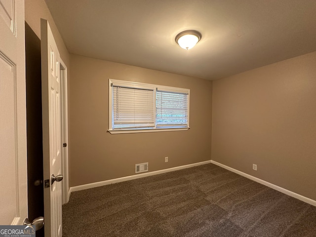 unfurnished bedroom featuring dark carpet