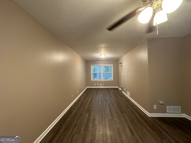 spare room with dark wood-type flooring and ceiling fan