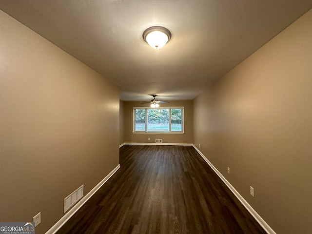 spare room featuring dark hardwood / wood-style flooring and ceiling fan