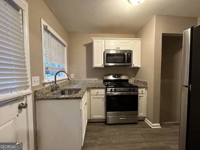 4310 Bakers Ferry Rd SW, Atlanta, GA 30331 - kitchen with appliances with stainless steel finishes, a sink, dark wood-style floors, dark stone countertops, and white cabinets
