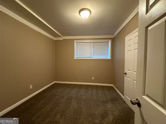 unfurnished room featuring dark colored carpet