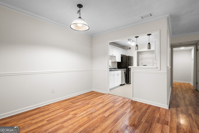 kitchen featuring pendant lighting, white cabinets, ornamental molding, and light wood-type flooring