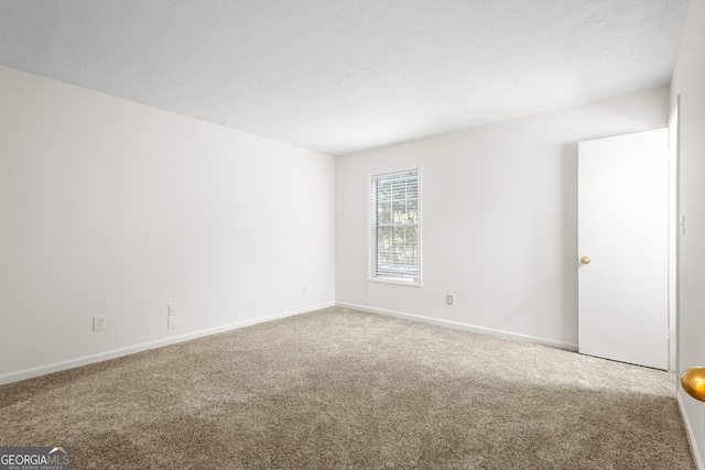 spare room featuring carpet floors and a textured ceiling