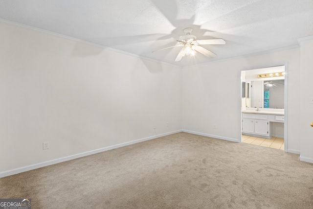 unfurnished bedroom with ceiling fan, sink, ensuite bathroom, crown molding, and light carpet