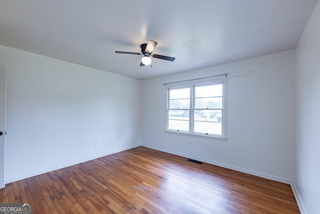 empty room with hardwood / wood-style flooring and ceiling fan