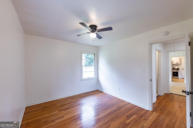 spare room featuring ceiling fan and hardwood / wood-style flooring