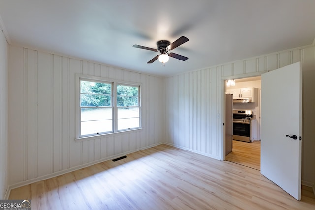 spare room featuring ceiling fan and light hardwood / wood-style flooring