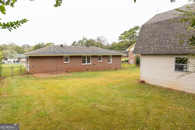 back of house featuring a lawn and a patio