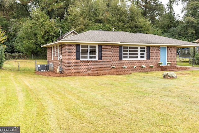 view of front of house with a front yard and a trampoline