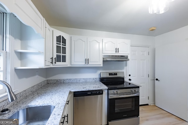 kitchen featuring white cabinetry, sink, light stone countertops, appliances with stainless steel finishes, and light wood-type flooring