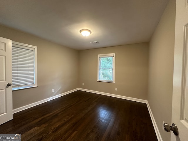 spare room featuring dark wood-type flooring