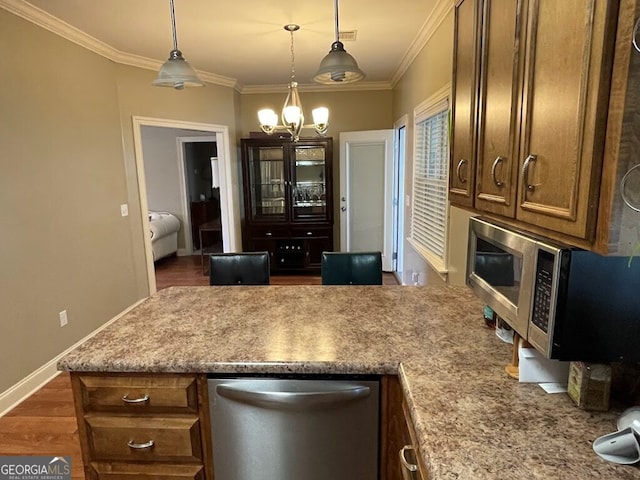 kitchen with crown molding, appliances with stainless steel finishes, decorative light fixtures, dark wood-type flooring, and a chandelier