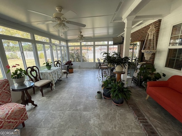 sunroom featuring ceiling fan and ornate columns