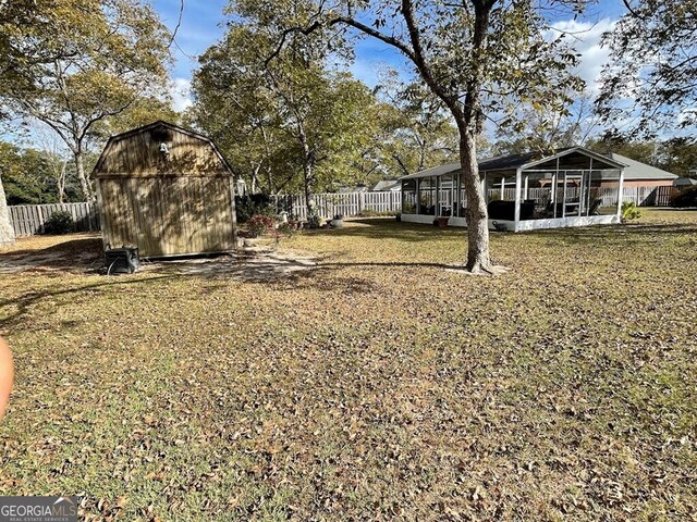 view of yard with a sunroom and a storage unit