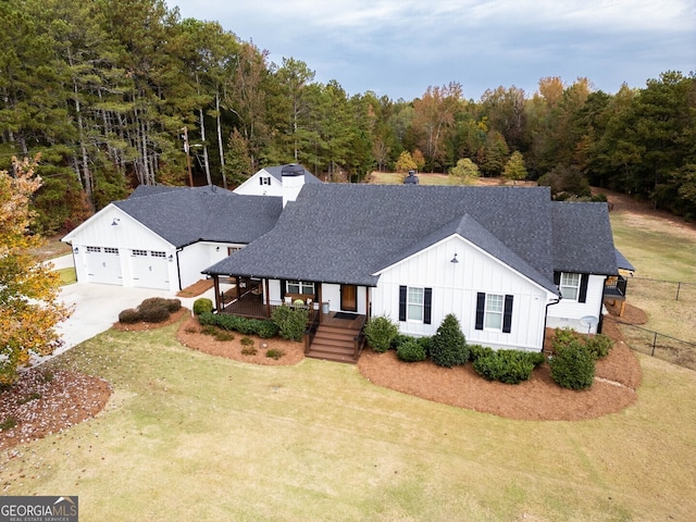 modern farmhouse style home with a garage, a porch, and a front lawn