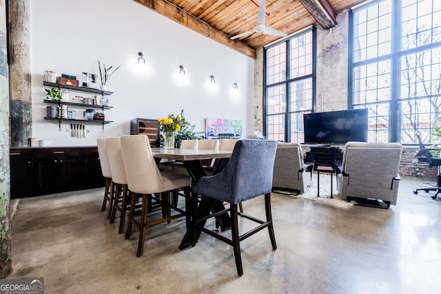 dining area with a towering ceiling, plenty of natural light, beamed ceiling, and wood ceiling