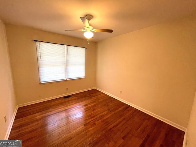 spare room featuring dark hardwood / wood-style flooring and ceiling fan