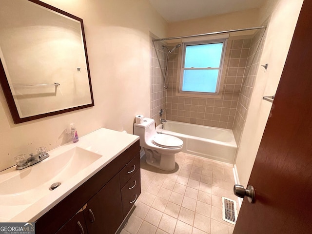 full bathroom with tile patterned flooring, tiled shower / bath, toilet, and vanity