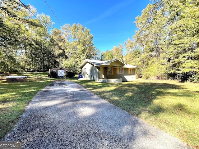 view of front of home featuring a porch, a front yard, and a storage unit