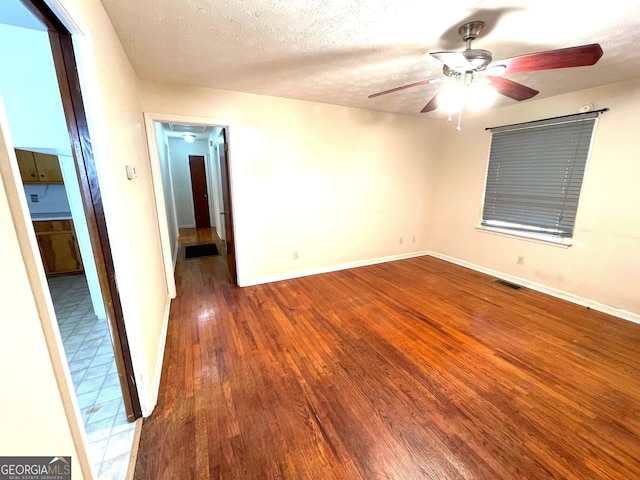 spare room featuring hardwood / wood-style floors, ceiling fan, and a textured ceiling