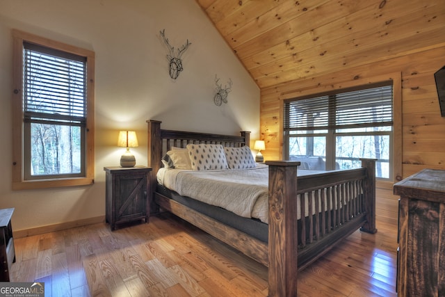 bedroom featuring high vaulted ceiling, wooden walls, hardwood / wood-style floors, and wooden ceiling