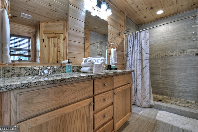 bathroom featuring walk in shower, vanity, wooden walls, and wood ceiling