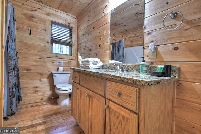 bathroom with toilet, wood ceiling, hardwood / wood-style floors, wood walls, and vanity