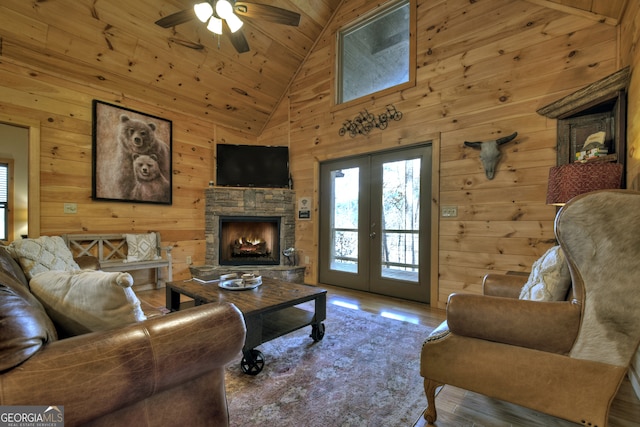 living room featuring high vaulted ceiling, wood walls, and wood-type flooring