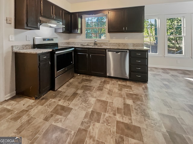 kitchen featuring a wealth of natural light, appliances with stainless steel finishes, and dark brown cabinets