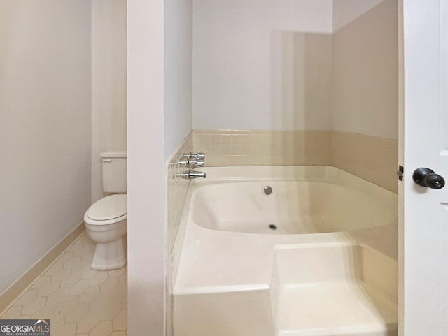 bathroom with toilet, a tub, and tile patterned floors