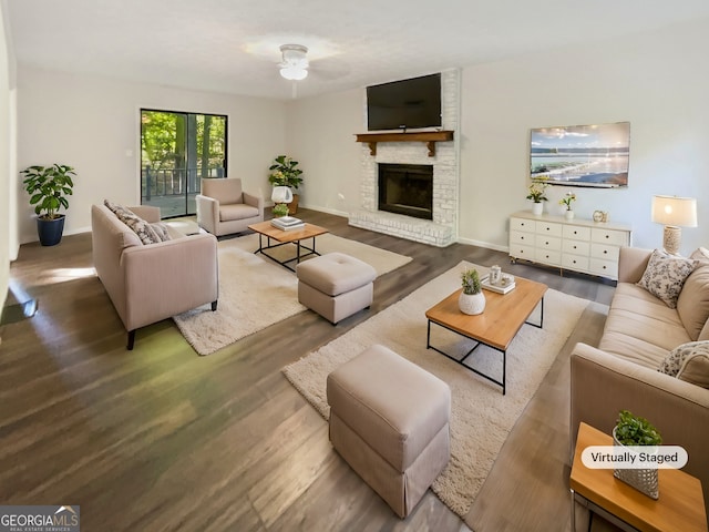 living room with hardwood / wood-style flooring, ceiling fan, and a brick fireplace