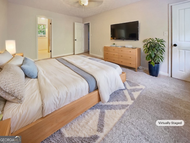 carpeted bedroom with ceiling fan and ensuite bath