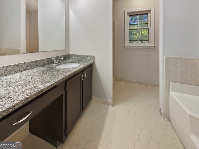 bathroom with a bath, vanity, and tile patterned floors