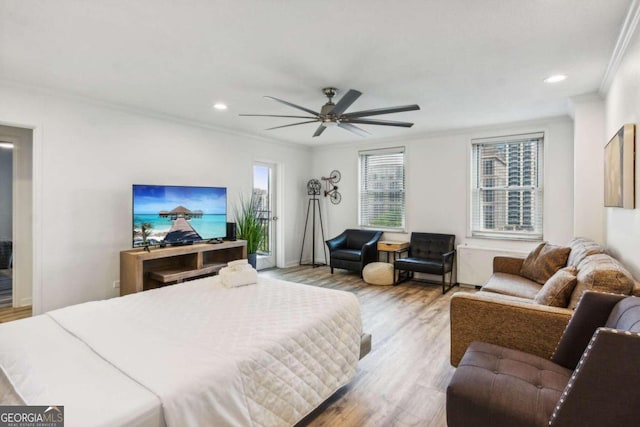 bedroom featuring light wood-type flooring, ceiling fan, and crown molding