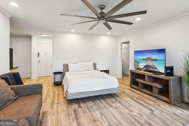 bedroom with light hardwood / wood-style flooring, ceiling fan, and crown molding