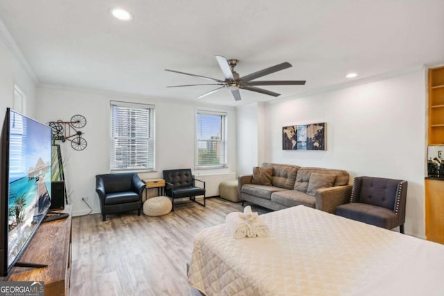 bedroom featuring ornamental molding, light hardwood / wood-style flooring, and ceiling fan