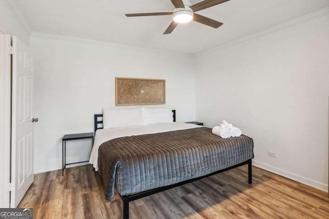 bedroom featuring hardwood / wood-style flooring, ceiling fan, and crown molding