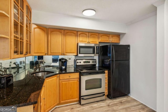 kitchen featuring light wood-type flooring, appliances with stainless steel finishes, sink, and crown molding