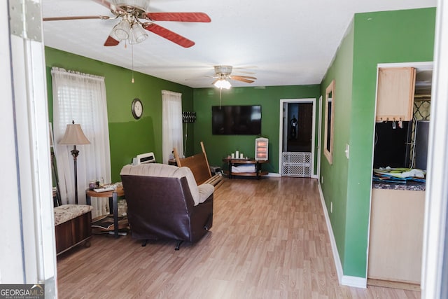 living room featuring ceiling fan and light wood-type flooring