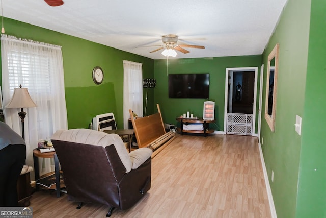 living room featuring light hardwood / wood-style flooring and ceiling fan