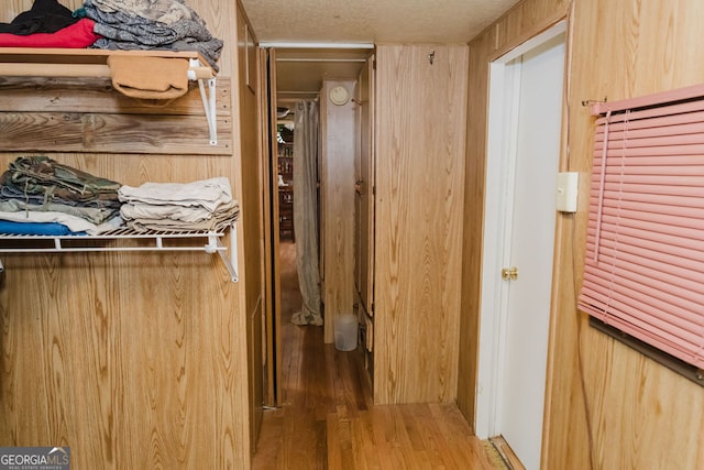 hallway featuring a textured ceiling and light hardwood / wood-style flooring