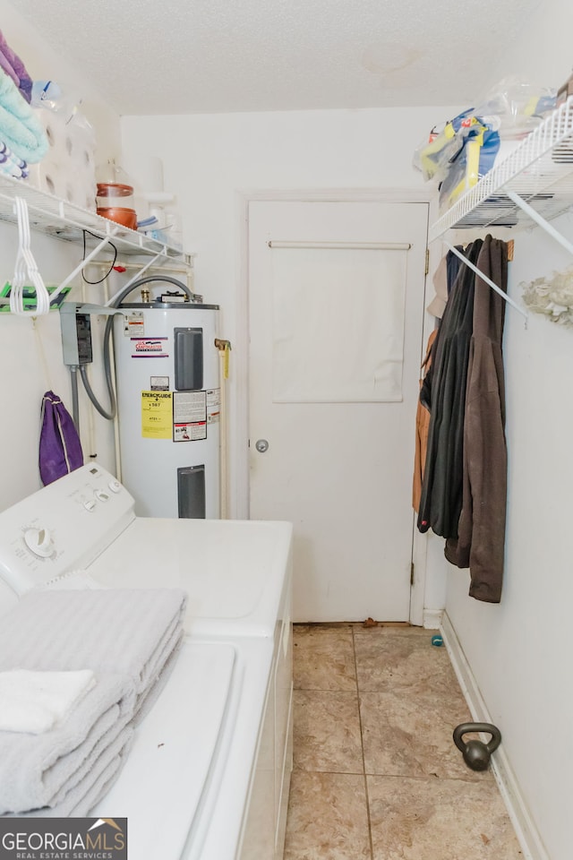 laundry area with separate washer and dryer, electric water heater, and light tile patterned floors