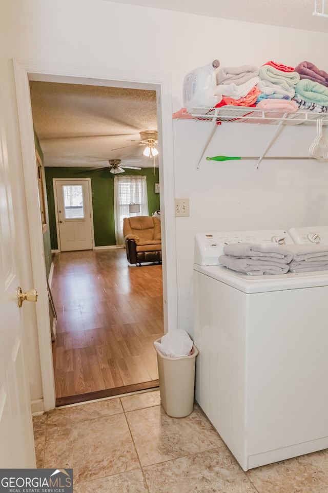 laundry area featuring a textured ceiling, light wood-type flooring, washer / clothes dryer, and ceiling fan