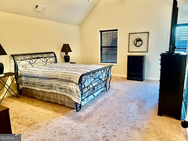 bedroom featuring light carpet and high vaulted ceiling